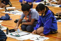 マレーシアの学生に書道を教えている様子
